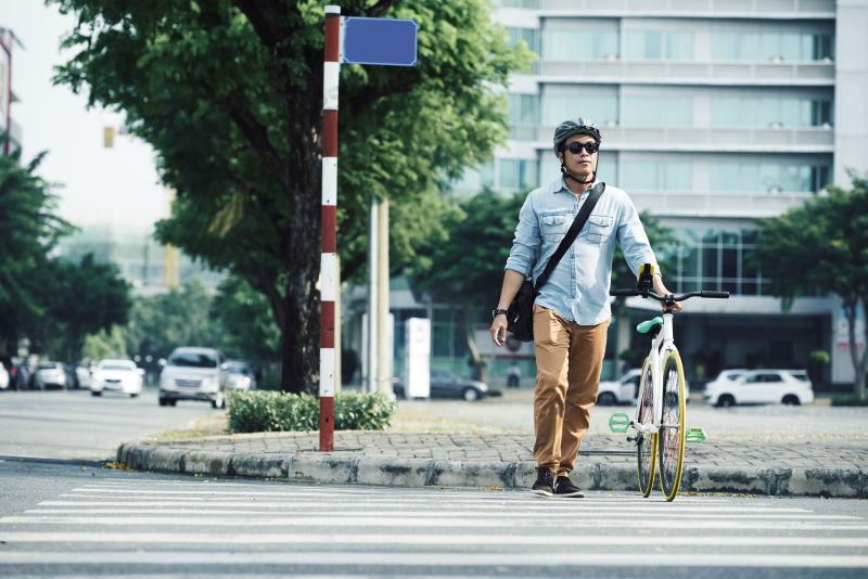推着自行车过马路的男人