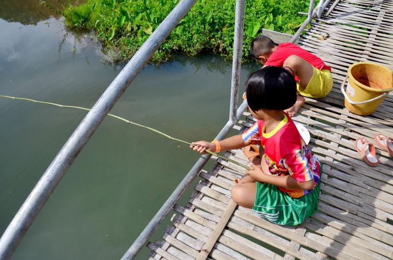 竹节桥上钓鱼的孩子