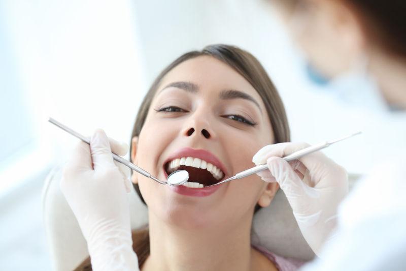 用仪器帮美女检查牙齿的牙医