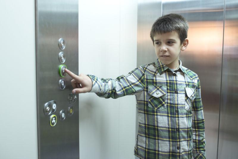 正在按电梯按钮的男孩