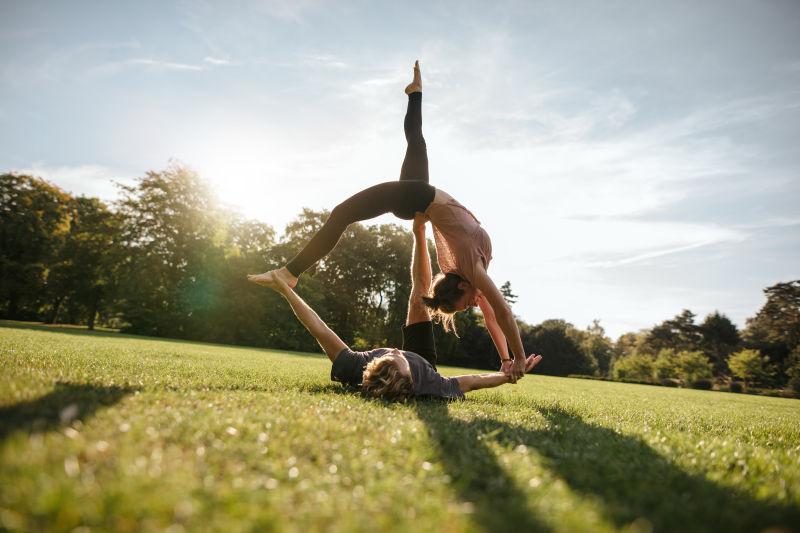 公园草地上在瑜伽锻炼的两个女人