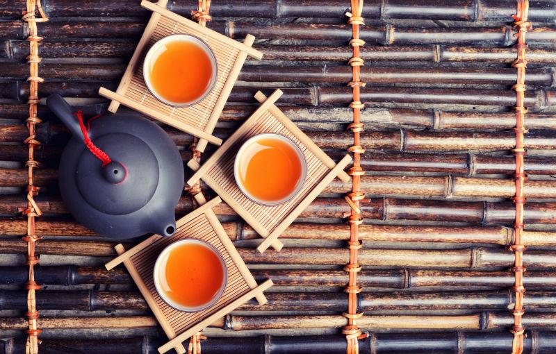 竹板上的茶壶茶杯和红茶