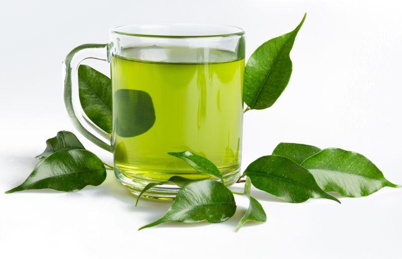 白色背景上的一杯绿茶和绿叶