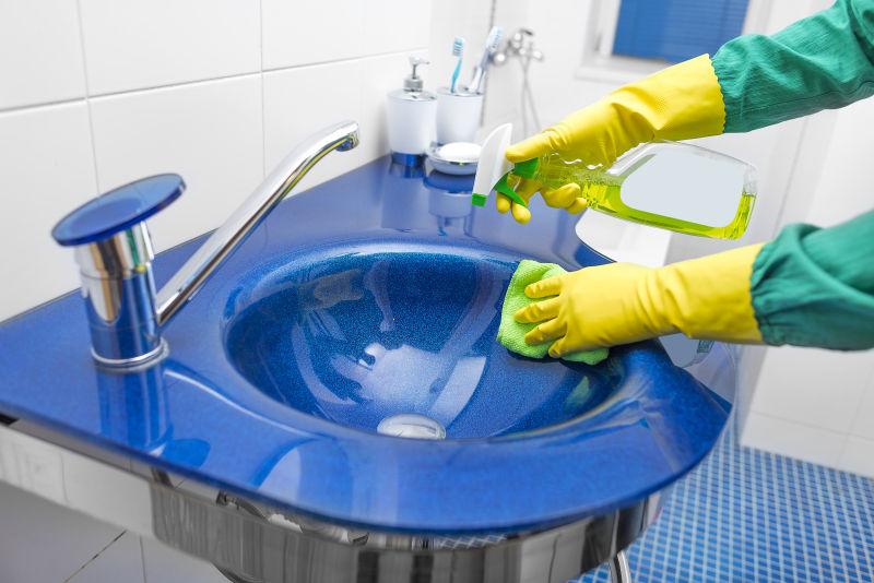 正在清洗蓝色洗手池的家庭主妇