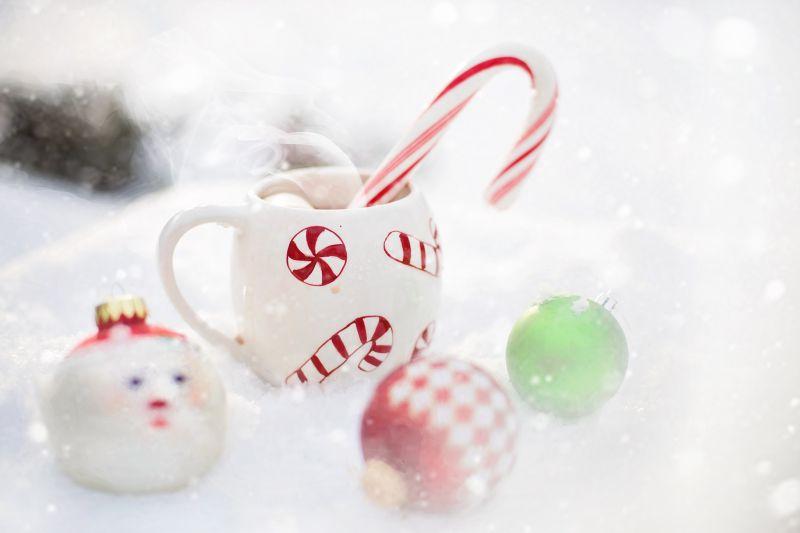 在圣诞节的雪地里的杯装棉花糖和热咖啡