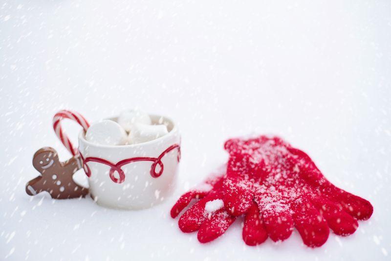 雪地里的咖啡与棉花糖周围的红色手套