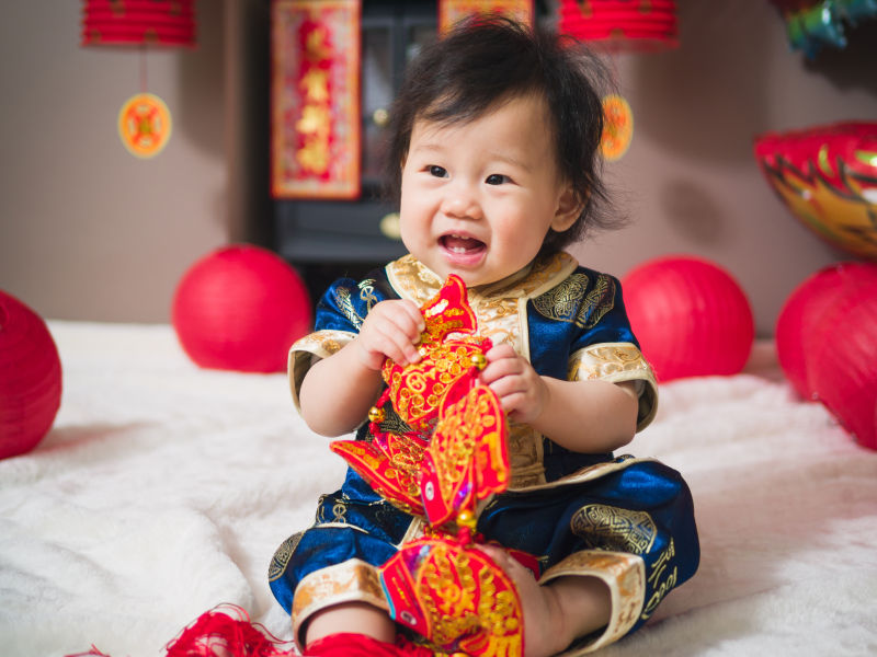 婴儿开怀大笑的在玩着春节装饰品