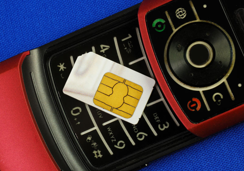 带有SIM卡的蜂窝电话隔离在无线通信的蓝色概念上
