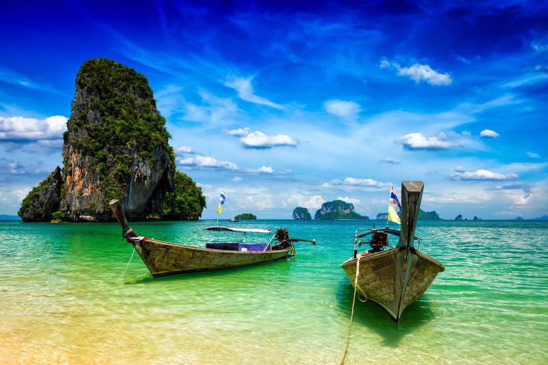 蓝天下泰国海滩上的长尾船