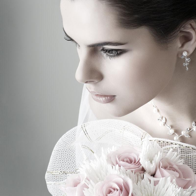 画着精致妆容的新娘捧着美丽的花束
