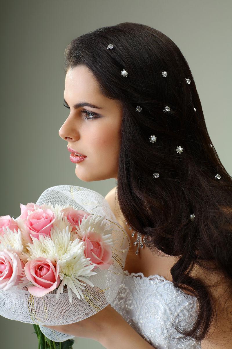 捧着美丽花束的新娘头上装饰着华丽的珠宝发饰