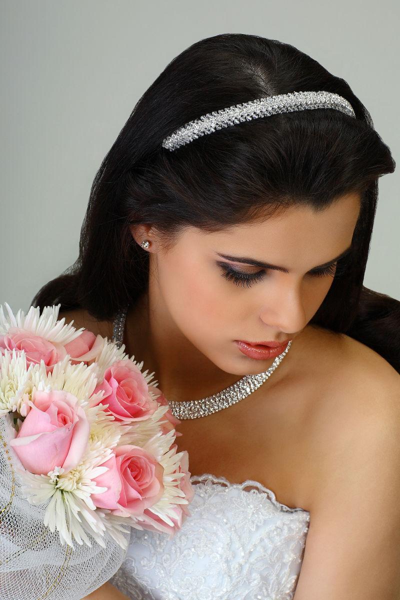 捧着花束的新娘带着钻石发箍和钻石项链