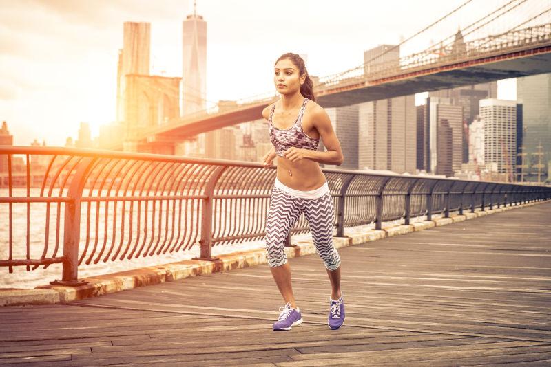 日落时分在纽约跑步的美丽的亚洲女子