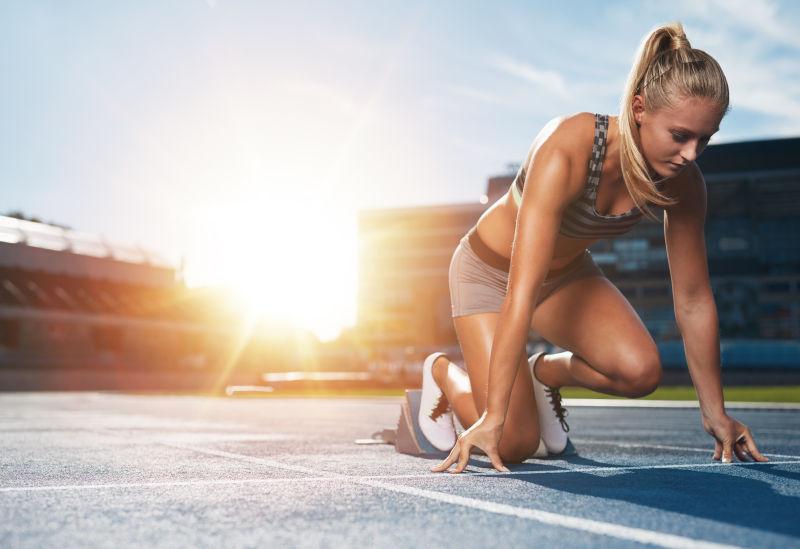 女子短跑运动员准备用太阳耀斑在跑道上进行体育锻炼
