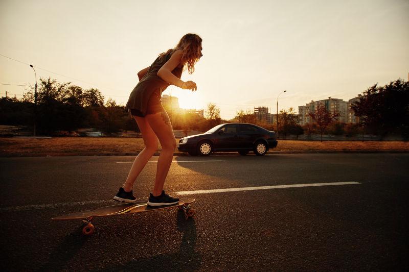 城市道路上玩滑板的女孩