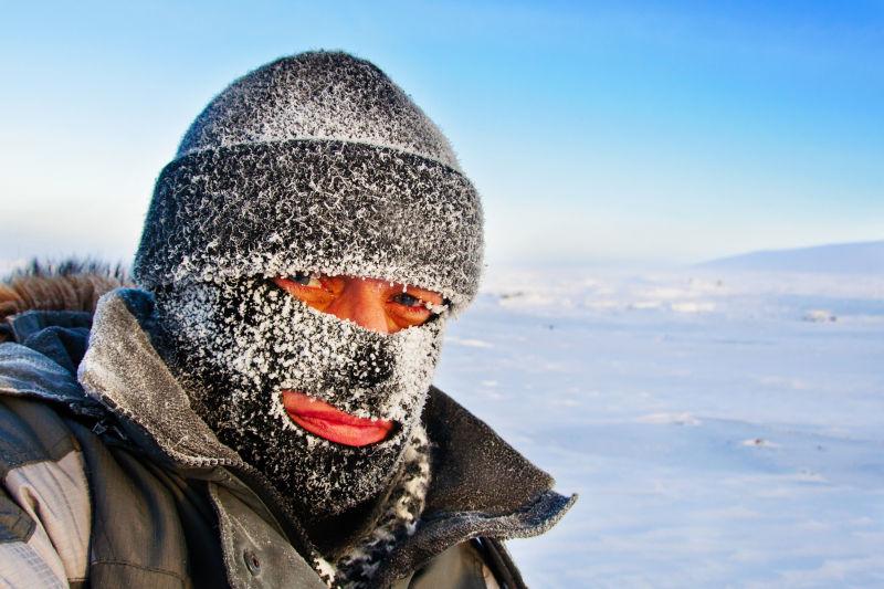 严寒的冬天一个戴帽子和滑雪面具的人的肖像