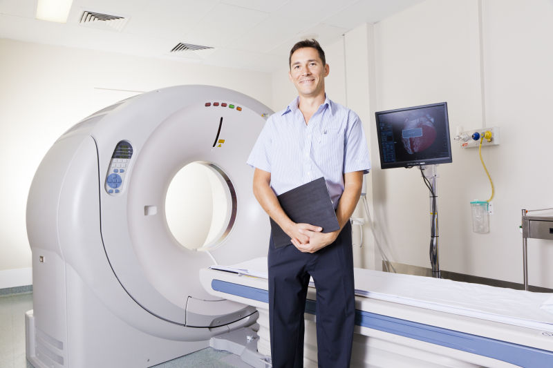 站在MRI扫描仪前面的年轻医生