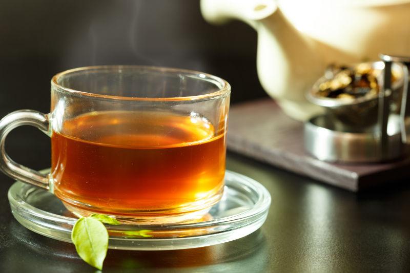 木桌上冒着热气的新鲜的一杯茶