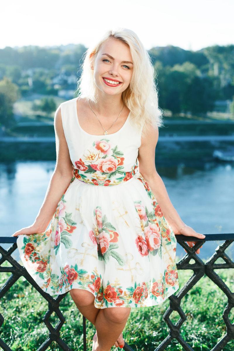 美丽的金发女孩夏天穿着裙子在河边