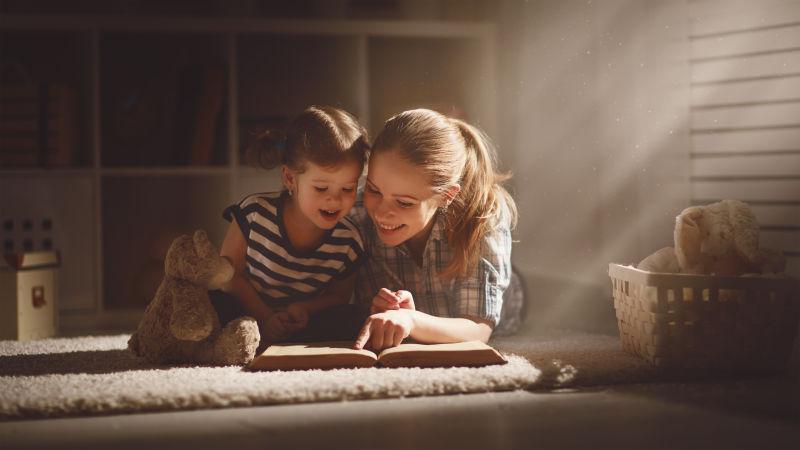 快乐的家庭母亲和女儿在家看书