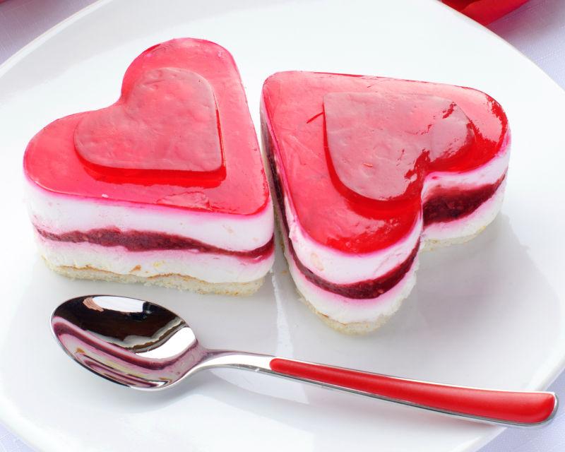 情人节白色盘子中两块心形草莓蛋糕的概念