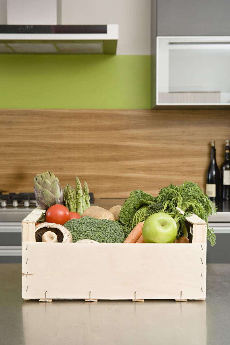 厨房桌面上放着蔬菜的木箱子