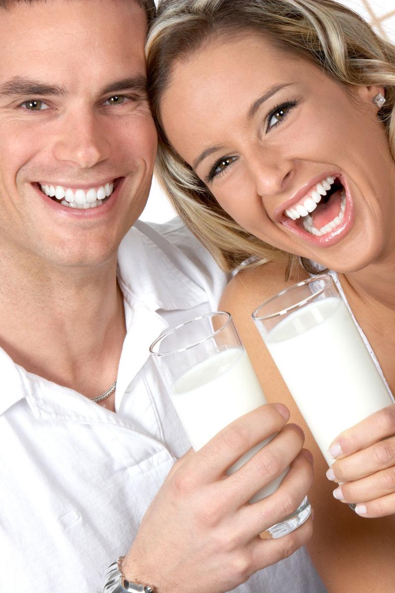 白色背景下年轻的情侣喝牛奶