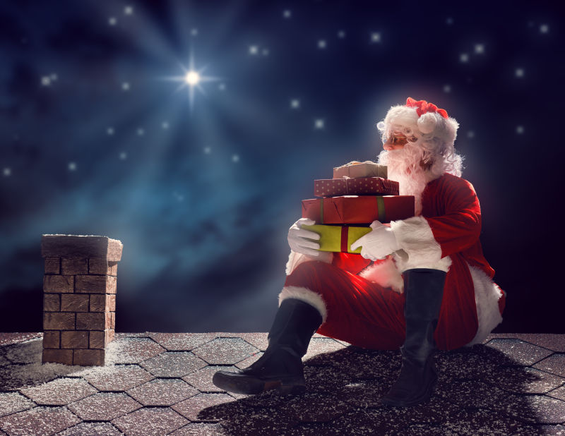 圣诞老人坐在屋顶上拿着礼物