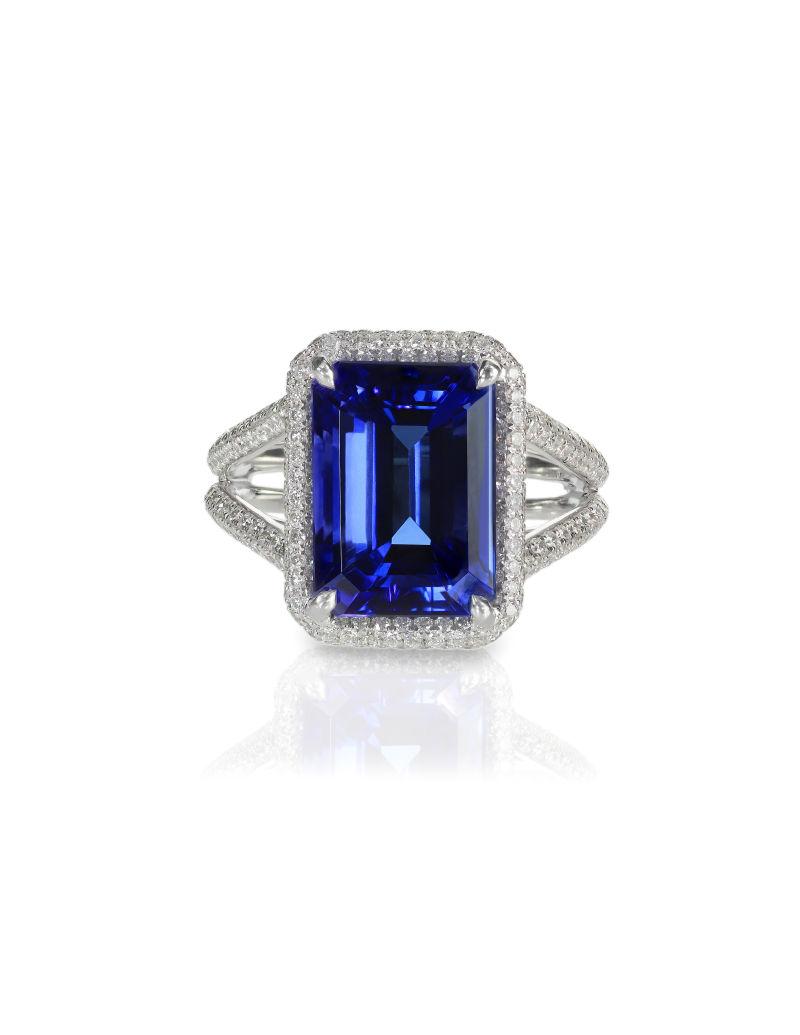 白色背景下镶嵌着蓝色宝石和钻石的戒指