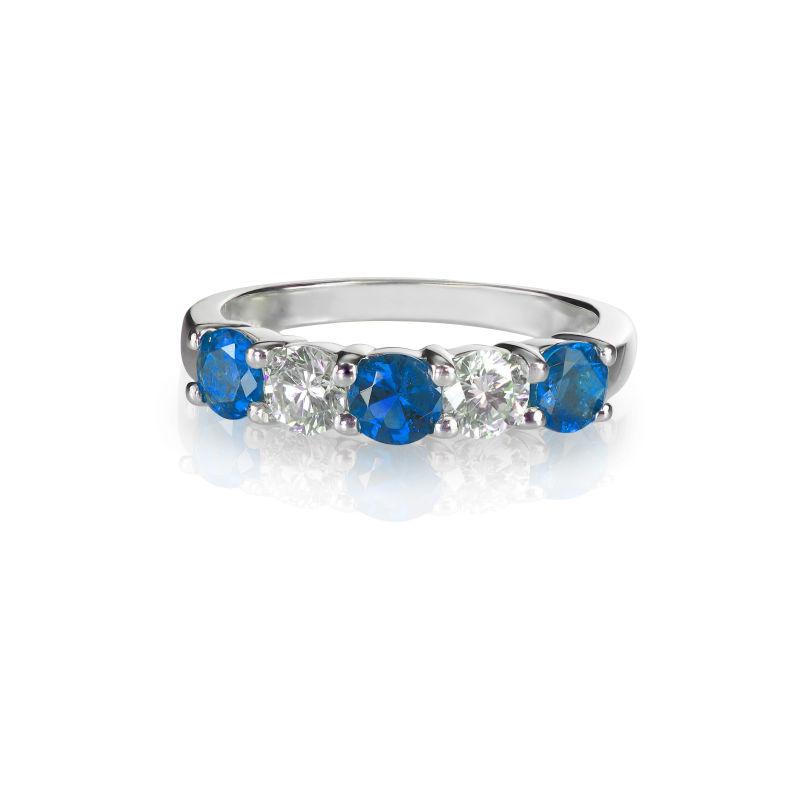 白色背景下镶嵌着蓝色宝石和钻石的名贵的戒指