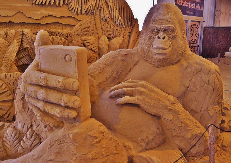 展览厅里的拿着手机的大猩猩艺术雕塑