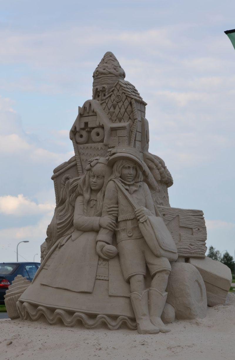 沙滩上城堡雕塑下的公主和王子沙雕