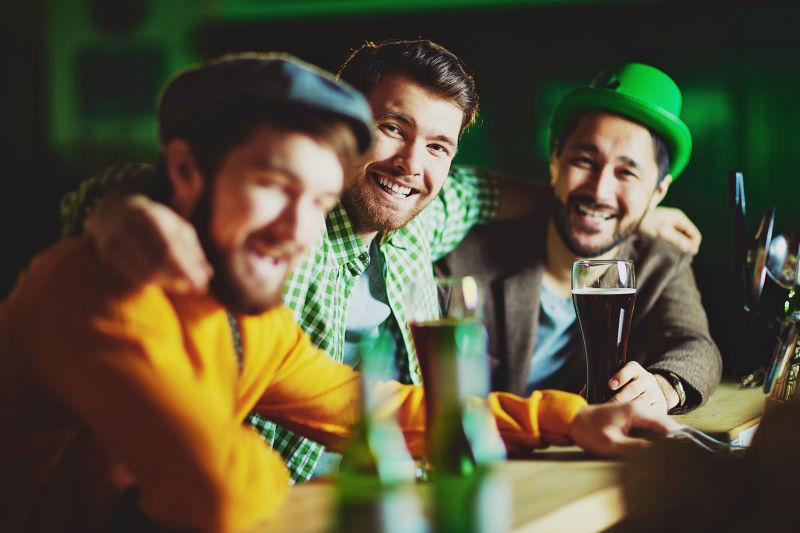 在酒吧喝着啤酒的三个男人