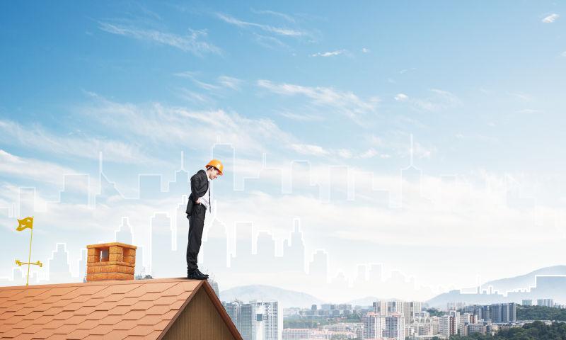 站在屋顶往下看的商人