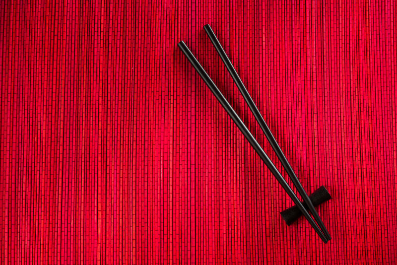 红色竹垫上的黑色筷子