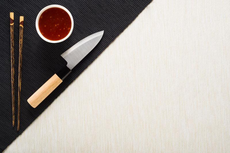 桌面上的刀和调料碗还有一双筷子