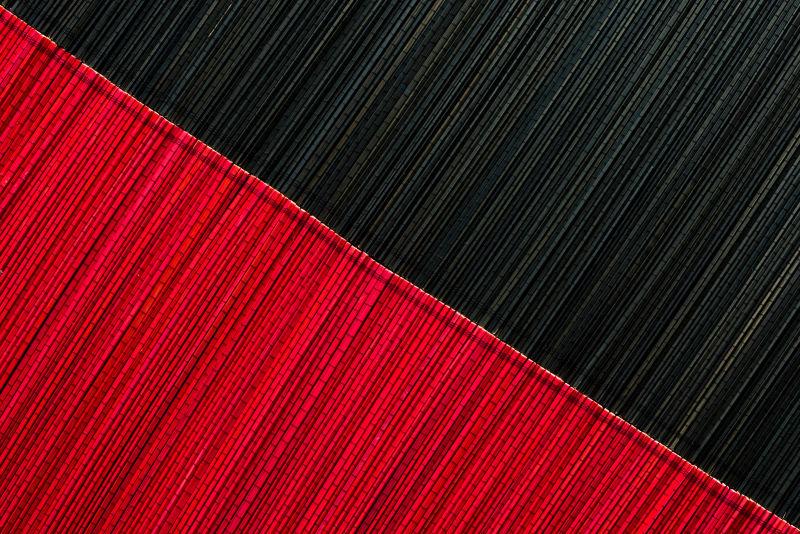 桌面上的红黑拼接的竹席垫子