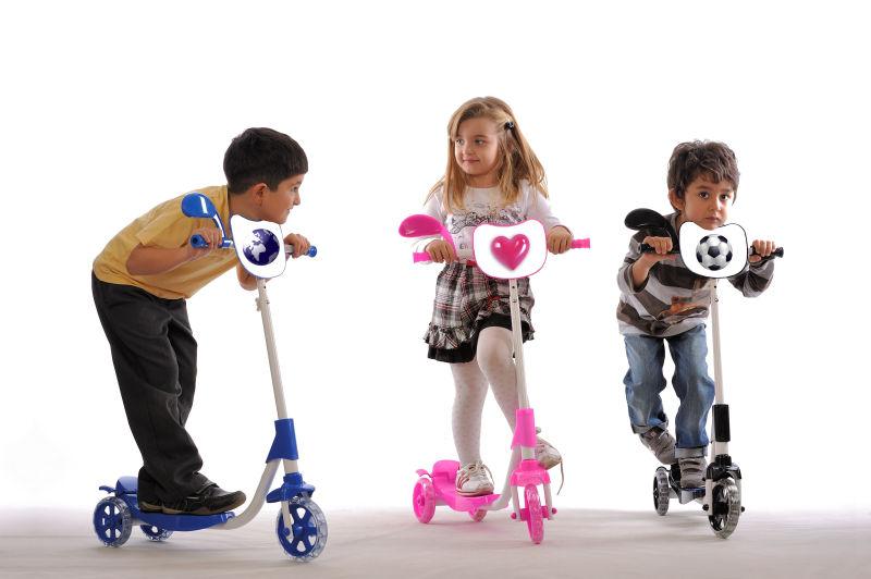孩子们玩他们的彩色滑板车