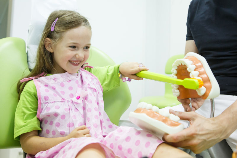 微笑的小女孩在刷牙模型
