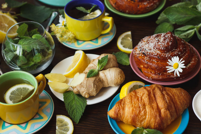 木桌上的茶杯姜根薄荷叶柠檬茶和面包