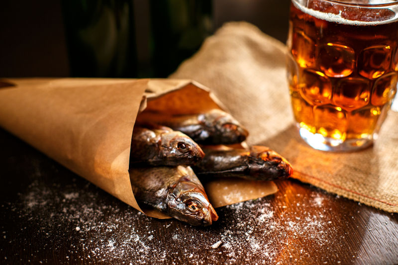 桌上晒干的鱼和装在杯子里的啤酒