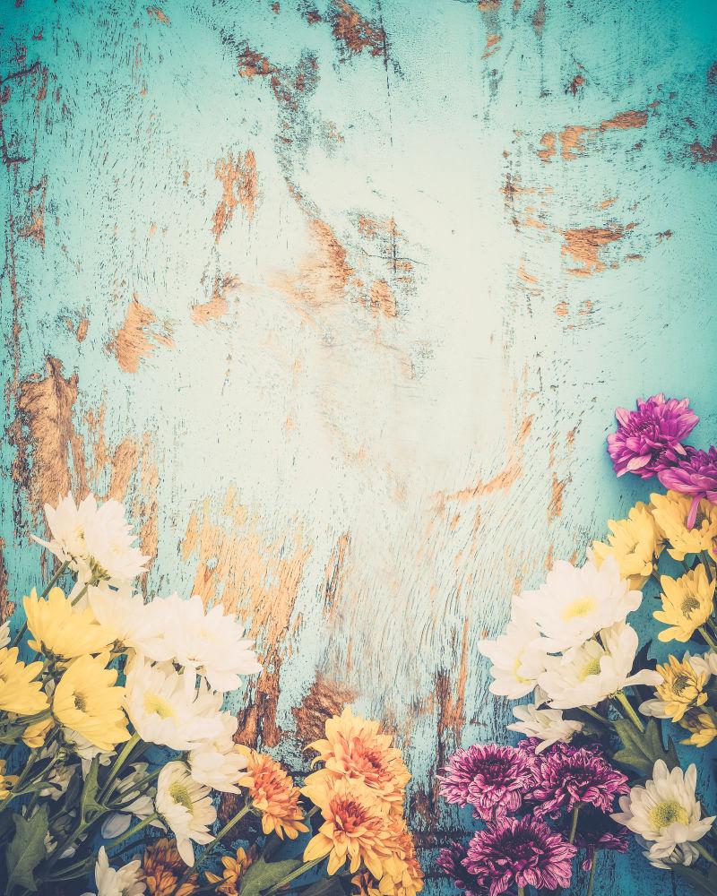 五颜六色的花在旧蓝色木板上