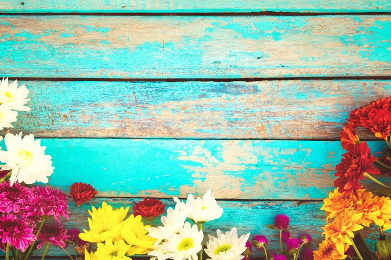 五颜六色的花在蓝色木板上