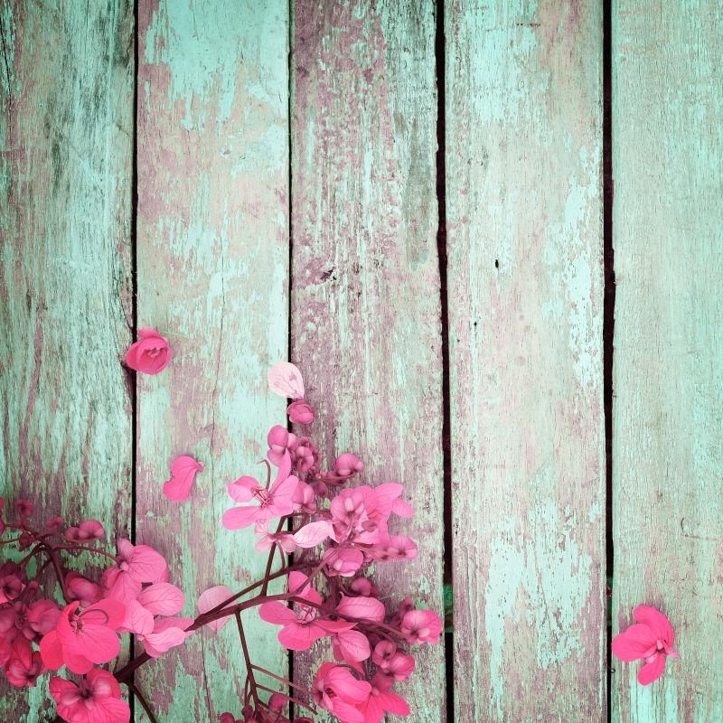 粉红色花朵上的古董木板背景