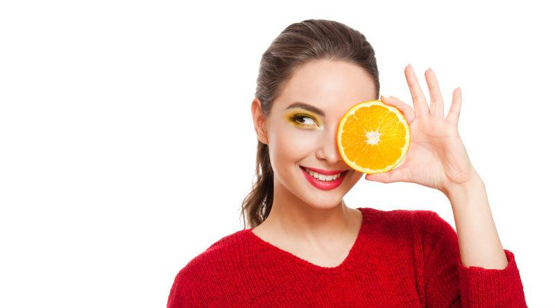 年轻的女人画着黄色眼影与柠檬