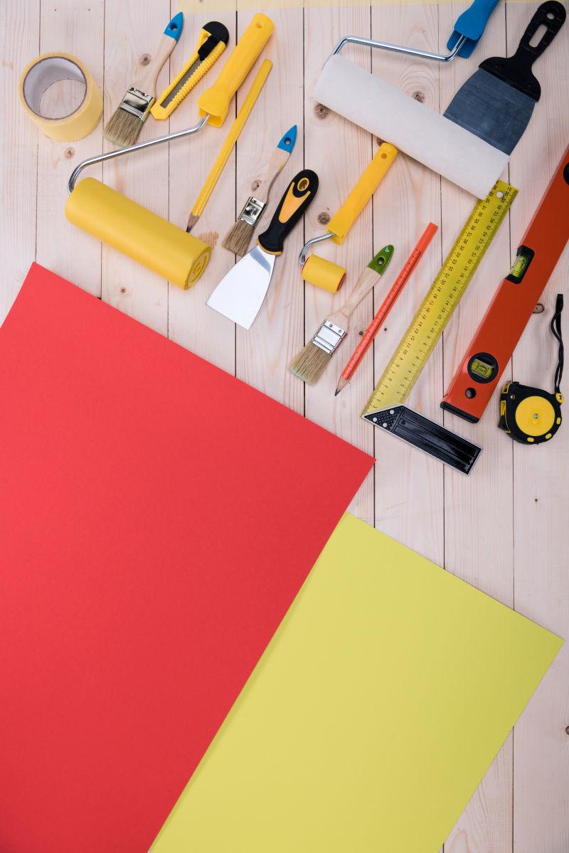 木桌上的彩色纸张和修理工具