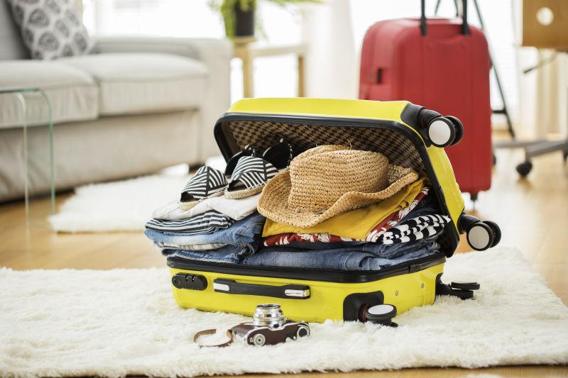 客厅里装满衣服的旅行箱旅行概念
