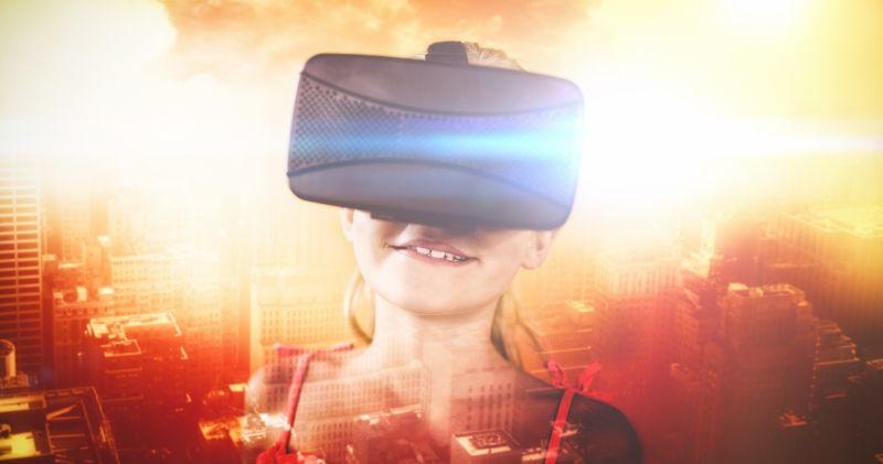 带着VR眼镜处于虚拟世界的微笑的小女孩