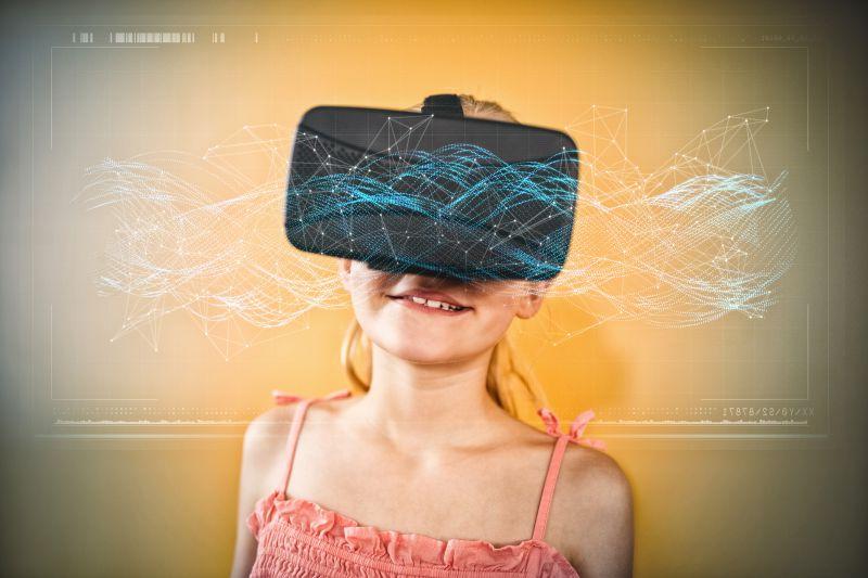 带着VR眼镜处于虚拟世界的可爱的小女孩