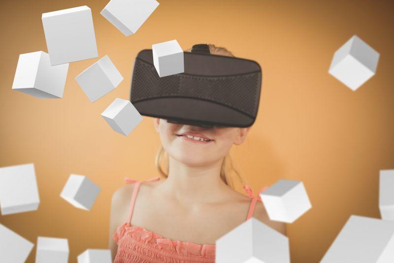 棕色背景下带着VR眼镜观看数字立方体的微笑的女孩